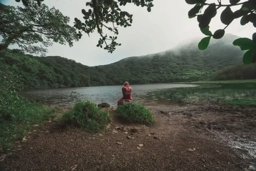 Hiker sitting beside the crater lake of Maderas Volcano