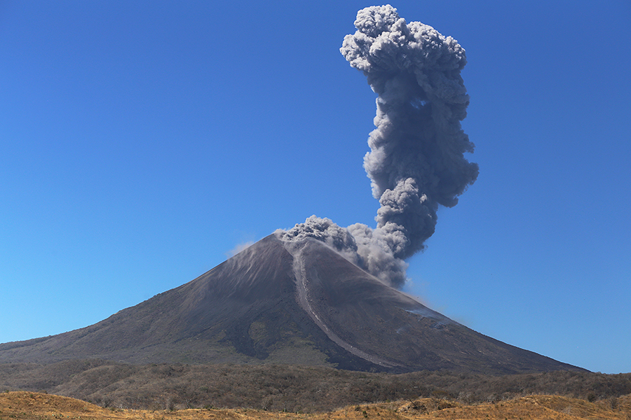 Cono simétrico del volcán Momotombo elevándose sobre el lago de Managua en Nicaragua"